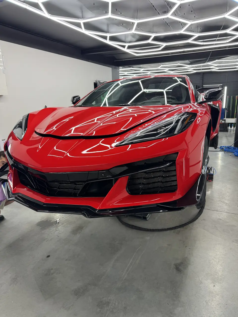 Червоний Chevrolet Corvette C8 під лампою контролю лакофарбового покриття