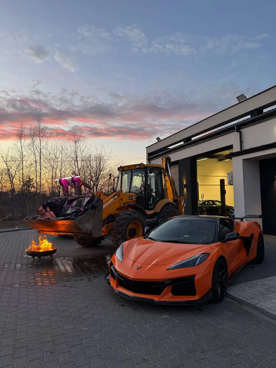 Помаранчевий Chevrolet Corvette C8 біля сервісу Redlines на заході сонця