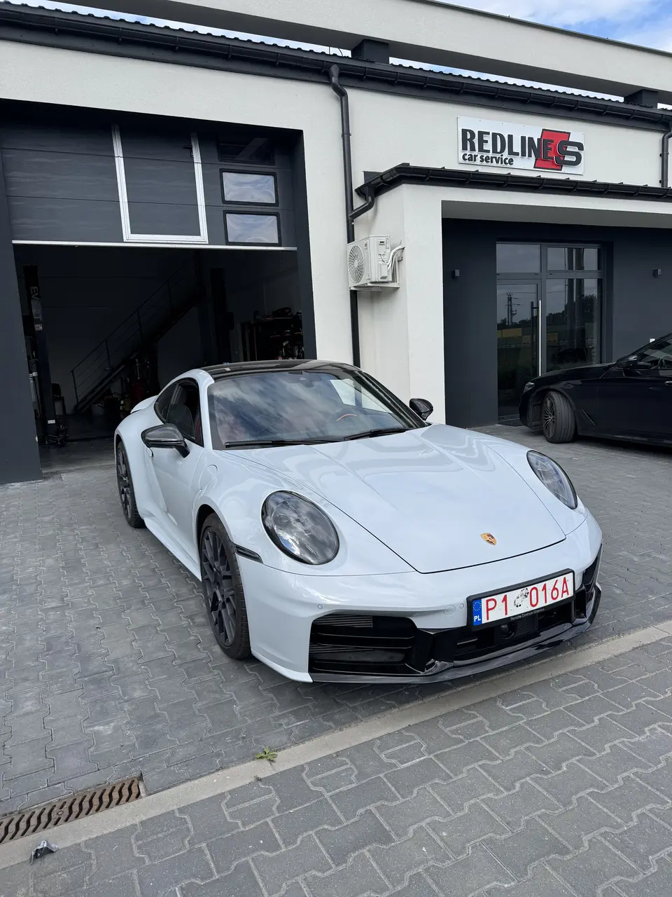 Білий Porsche 911 біля майстерні Redlines